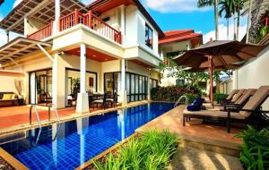 a villa with a swimming pool in front of a house at Laguna Fairway 3B villa-golf view in Laguna Phuket