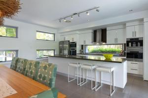 a kitchen with a bar with chairs and a table at Yaroomba Beach House in Yaroomba +24 photos