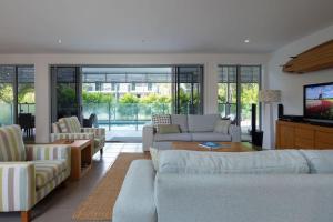 a living room with couches and a tv at Yaroomba Beach House in Yaroomba