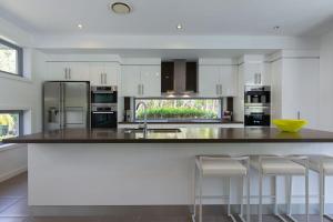 a kitchen with a large island with bar stools at Yaroomba Beach House in Yaroomba