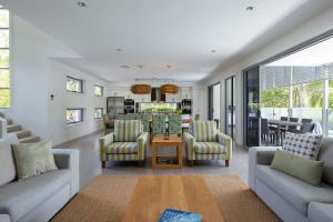 a living room with two couches and a table at Yaroomba Beach House in Yaroomba
