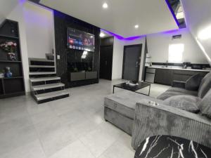 a living room with a couch and a television at Villas Safir en Valle de Gpe in Los Hornos
