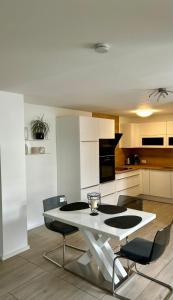 a kitchen with a white table and chairs at Apartments WK in Cologne