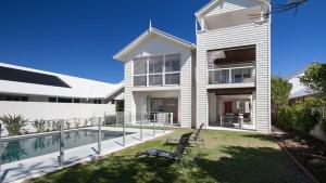 a house with a yard with a swimming pool at Seaside Beach House in Marcoola +9 photos