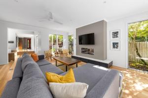 a living room with a couch and a tv at Seaside Beach House in Marcoola