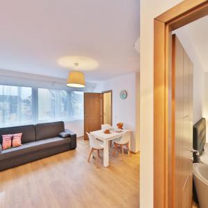 a living room with a couch and a table at R&eacute;sidence les C&egrave;dres in Strasbourg
