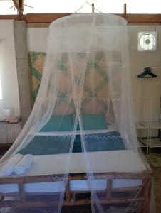 a bed in a room with a mosquito net at Kalma Kubo Siargao in San Isidro