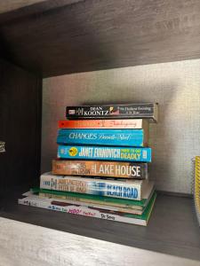 a stack of books sitting on a shelf at Waxberry Trailer by Kings Canyon and Sequoia National Parks in Squaw Valley