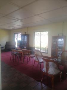 an empty room with tables and chairs and windows at Munro haputale in Haputale