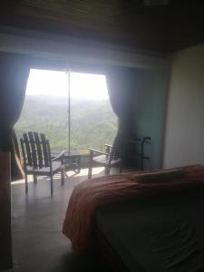 a bedroom with a bed and a window with a view at Munro haputale in Haputale