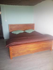 a bedroom with a wooden bed with a wooden headboard at Munro haputale in Haputale