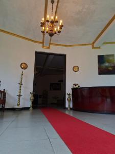 a large room with a red carpet and a chandelier at Royal Mount Hotel in Pussellawa