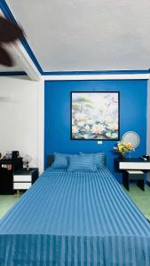 a blue bedroom with a large bed in a room at Favos Bích Động in Vũ Lâm
