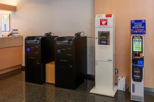 two atm machines are next to a cash register at HOTEL MYSTAYS Higashi Ikebukuro in Tokyo