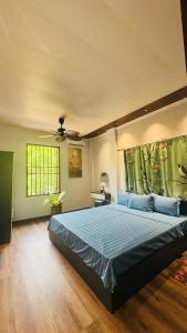 a bedroom with a large bed with blue sheets at Favos Bích Động in Vũ Lâm