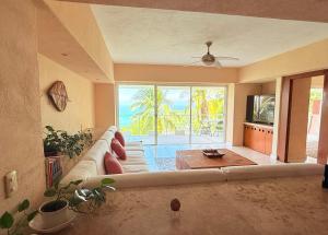 a living room with a large couch and a large window at Rincon Frente al mar in Acapulco