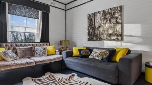 a living room with two couches and a rug at Le Petit Chateau in Medlow Bath