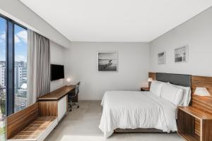 a hotel room with a bed and a desk at Fiesta Inn Express Cancún Cumbres in Cancún +47 photos