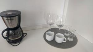 a table with three wine glasses and a blender at Lagoa Flats in Lagoa Santa
