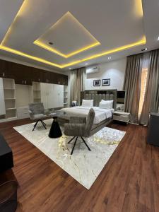 a bedroom with a bed and a table and a rug at DOD Residence I Cozy 3BR with Fast Wifi in Ikuata