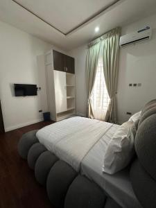 a bedroom with a large bed and a window at DOD Residence I Cozy 3BR with Fast Wifi in Ikuata