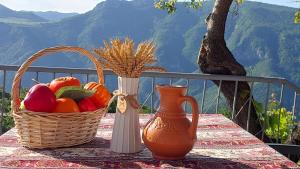 a basket of fruit and a vase on a table at Gohar Bed and Breakfast in Tatʼev