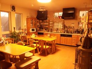 a kitchen with wooden tables and chairs in a kitchen at Tokyo8home Hachioji 東京民宿 八王子之家 in Hachioji