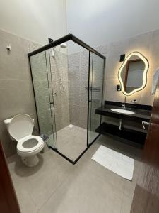 a bathroom with a shower and a toilet and a sink at Casas Pantanal - Privacidade e conforto no centro de Bonito in Bonito +35 photos