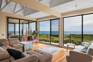 a living room with large windows and the ocean at Amazing Ocean Views with Spa in Surf Beach