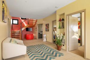 a living room with a white chair and a rug at Amazing Ocean Views with Spa in Surf Beach