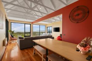 a living room with a large clock on the wall at Amazing Ocean Views with Spa in Surf Beach +11 photos