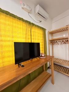 a flat screen tv sitting on top of a wooden table at NOGS Homestay, near Magpupungko, Siargao Island Surfings Spots in Pilar