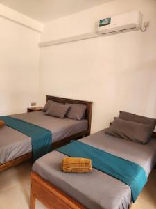 a bedroom with two beds and a air conditioner at Trinco salli beach resort in Trincomalee