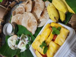 a plate of food with different types of bread and fruit at Trinco salli beach resort in Trincomalee