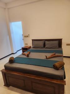a bedroom with a large bed with two logs on it at Trinco salli beach resort in Trincomalee