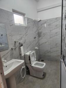 a bathroom with a white toilet and a sink at Trinco salli beach resort in Trincomalee +11 photos