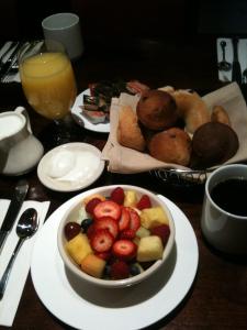 a table topped with a bowl of fruit and a plate of food at Washington Square Hotel in New York
