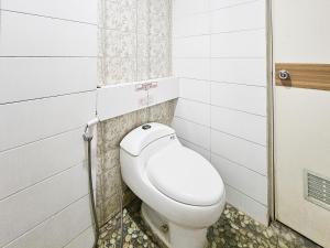 a bathroom with a white toilet in a stall at Urbanview Java Living Sigura Gura in Betek