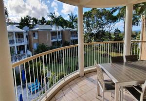 a balcony with a table and chairs on a porch at Serenity Apartments Noosa in Noosa Heads