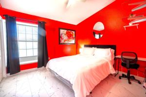 a red bedroom with a bed and a chair at Private Guestrooms OR Entire Home Rental in North Las Vegas in Las Vegas