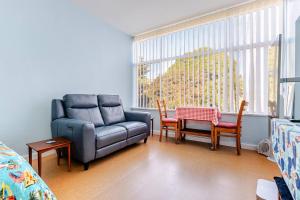 a living room with a couch and a table and a chair at Captain's Pick at Manly Beach plus Parking in Sydney