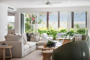 a living room with a white couch and a large window at Lucy - Noosa - Noosaville in Noosaville