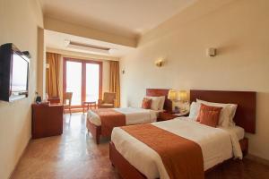 Postel nebo postele na pokoji v ubytování Royal Sarovar Portico Siliguri + 37 fotografií