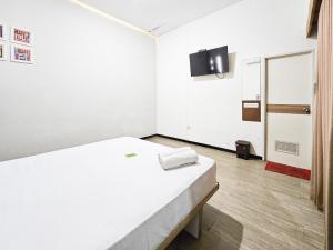 a white room with a bed and a tv at Urbanview Java Living Sigura Gura in Betek +41 photos