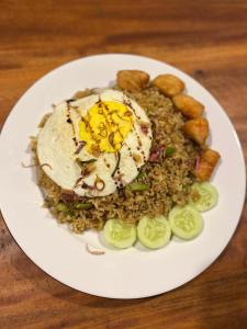 a plate of food with an egg on top of rice at Bunga Lodge Tetebatu in Tetebatu +54 photos