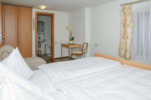 1 dormitorio con cama blanca y mesa en Gasthof Hofbauer, en Schwanenstadt