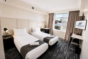a hotel room with two beds and a window at Woodroffe Hotel in Gold Coast +16 photos