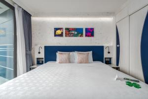 a bedroom with a large bed with a blue headboard at Hotel Clover Patong Phuket in Patong Beach