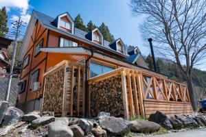 a house with a bunch of logs at TANIGAWA GOODY Lodge in Minakami