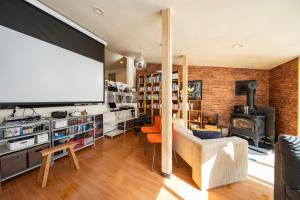 a living room with a tv and a brick wall at TANIGAWA GOODY Lodge in Minakami
